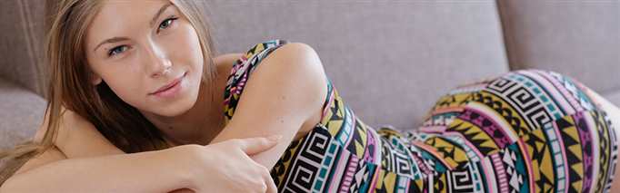 A young woman lying on her front in a tight, sexy dress thinking about how she's getting spanked